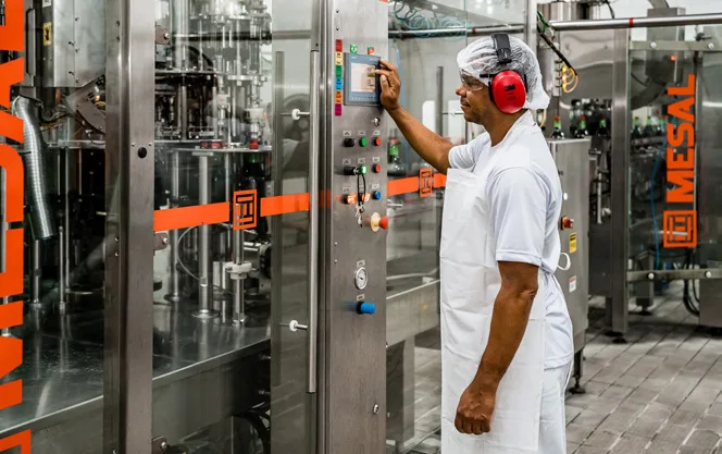 Colaborador da Risso operando o painel de controle da linha de envase