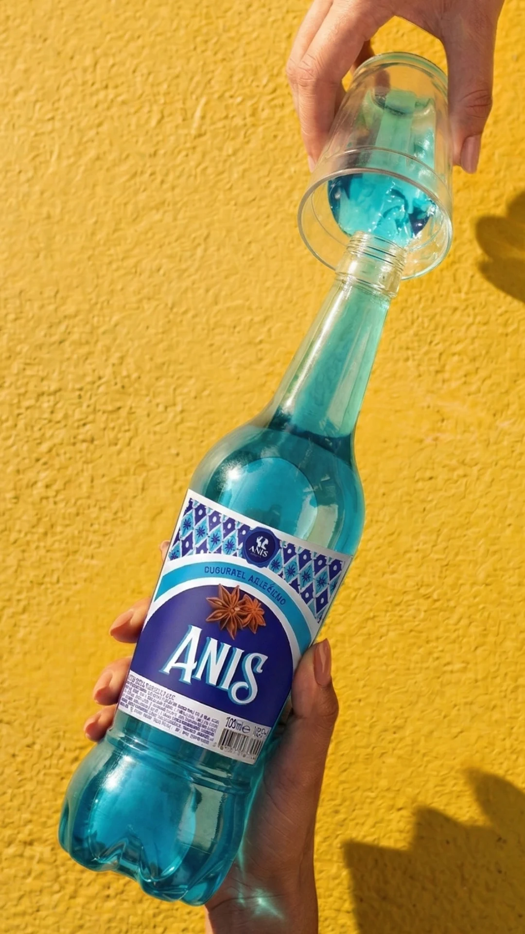 Garrafa de coquetel Anis sendo servida, com o selo Coquiteís